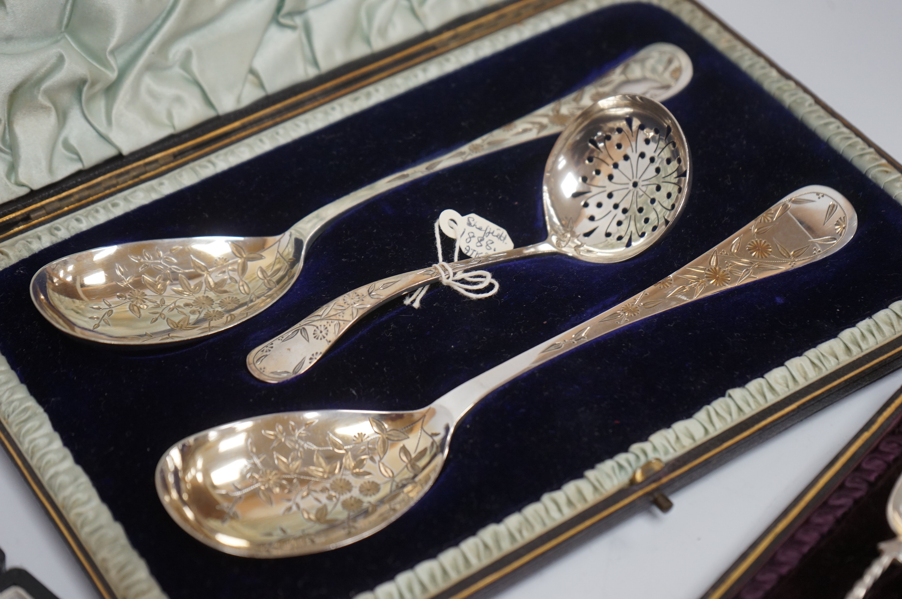 A cased pair of Victorian silver serving spoons and matching sifter spoon with engraved floral decoration, Atkin Brothers, Sheffield, 1888, together with a cased set of six late Victorian silver coffee spoons and matchin